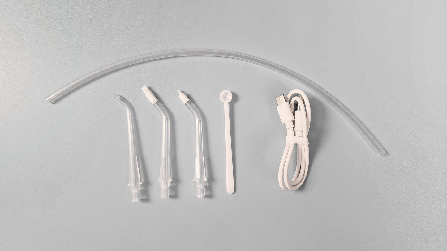 Set of dental water flosser nozzles and hose on a gray background