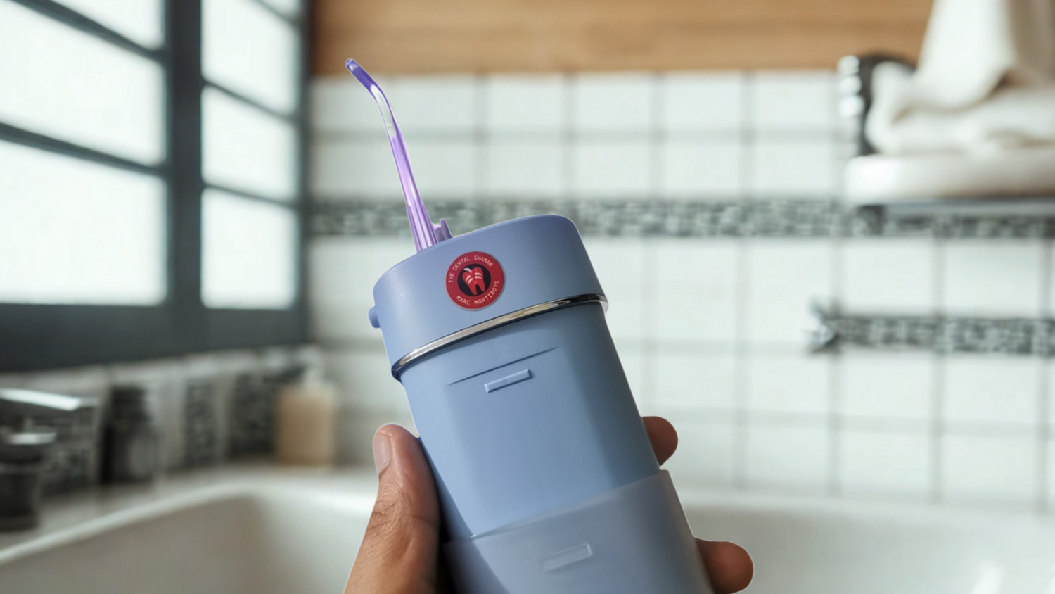 Person holding a blue water flosser in a kitchen.