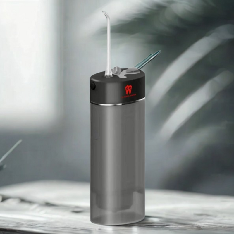 Gray water flosser on a marble surface with a blurred background.