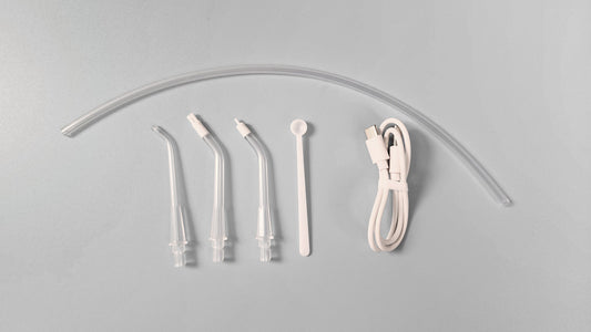 Set of dental water flosser nozzles and hose on a gray background